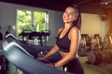 Spor salonunda çalışan genç bir kadın sağlıklı bir hayat sürüyor.