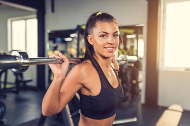 Gülümseyen kadın fitness sınıfta büyük halter yukarı çekerek 