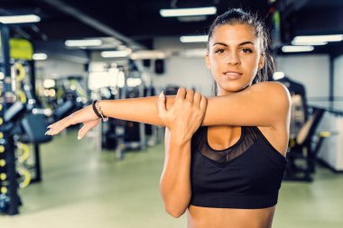 Spor salonunda bir çalışmadan sonra germe egzersizleri yapıyor kızlar