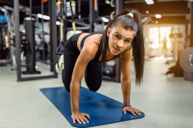 Uygun kız trx arka omurga ve duruş için tahta egzersiz yapıyor