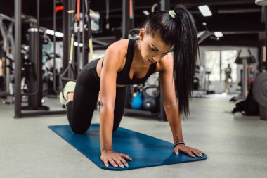 Uygun kız trx arka omurga ve duruş için tahta egzersiz yapıyor