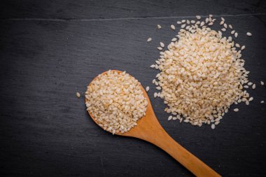 Beyaz Susam siyah granit backgroud kaşık içinde