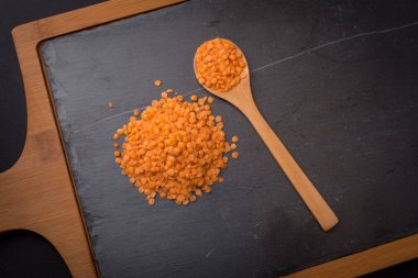 Bir kaşık siyah granit zemin üzerine kırmızı mercimek