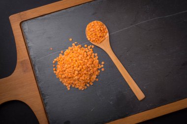 Bir kaşık siyah granit zemin üzerine kırmızı mercimek