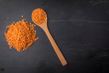 Bir kaşık siyah granit zemin üzerine kırmızı mercimek