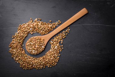 Karabuğday kahverengi siyah bir ahşap zemin üzerine bir kaşık. Yakın çekim. Yukarıdan görüntülemek.