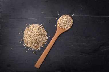 Kaşık siyah taş zemin, kopya alanı üzerinde Quinoa tohumları