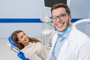 Diş hekimi ve diş kliniği hastada gülümseyen 