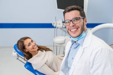 Diş hekimi ve diş kliniği hastada gülümseyen 