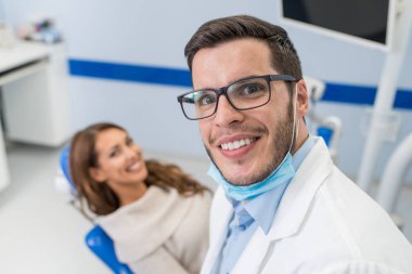 Diş hekimi ve diş kliniği hastada gülümseyen 