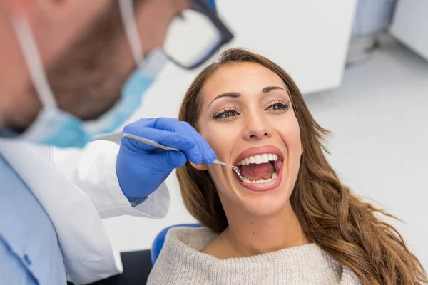 Joven Dentista Varón Confiado Tratamiento Médico Una Paciente Femenina Clínica — Foto de Stock