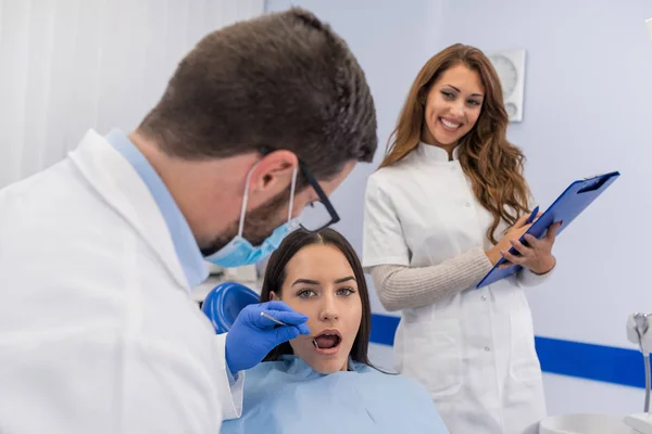 Joven Dentista Varón Confiado Tratamiento Médico Una Paciente Femenina Clínica — Foto de Stock