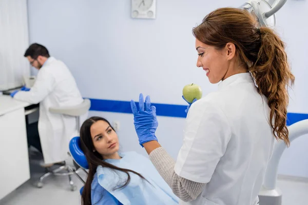 Dentist gives the patient an apple