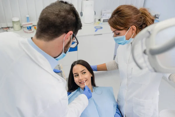歯科医は患者の歯の白さを調べる — ストック写真