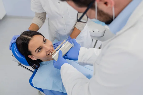 歯科医は患者の歯の白さを調べる — ストック写真