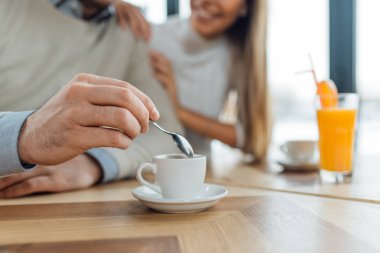 Fincan kahve kaşık tutan adam el ele