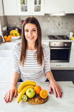 Kızın önünde ahşap plaka üzerinde yiyecek çeşitler.