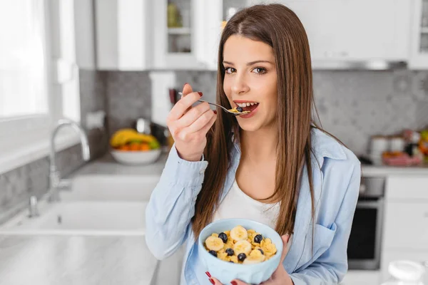 Aantrekkelijke jonge vrouw eten gezond ontbijtgranen thuis — Stockfoto