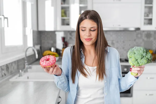 Foto van mooie vrouw met broccoli en cake — Stockfoto