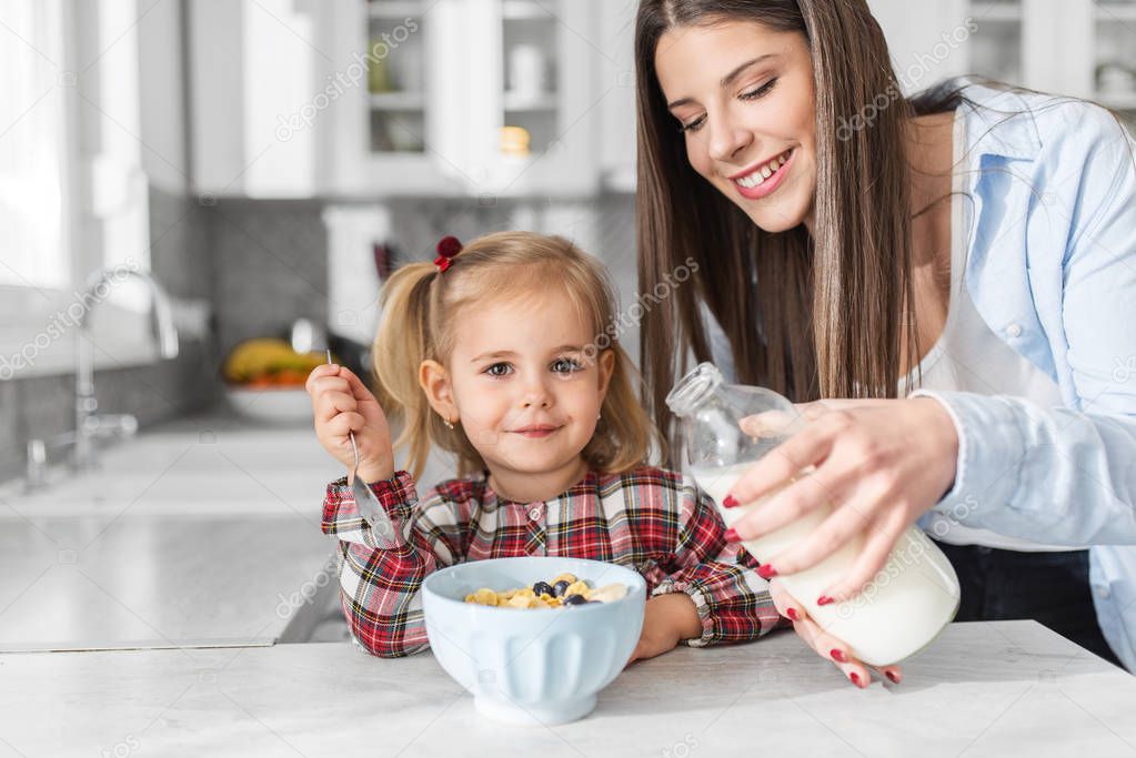 Mother and daughter having breakfast in kitchen