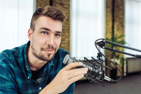 Joven grabando un podcast sonriendo a la cámara, de cerca —  Fotos de Stock