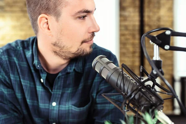 Jonge knappe man aan het praten op microfoon, online radio, podcast. — Stockfoto