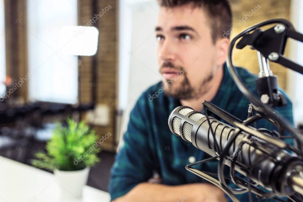 Young man recording a podcast. Close up