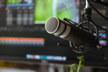 Bilgisayar arka planının önündeki mikrofon. Post prodüksiyon programı.