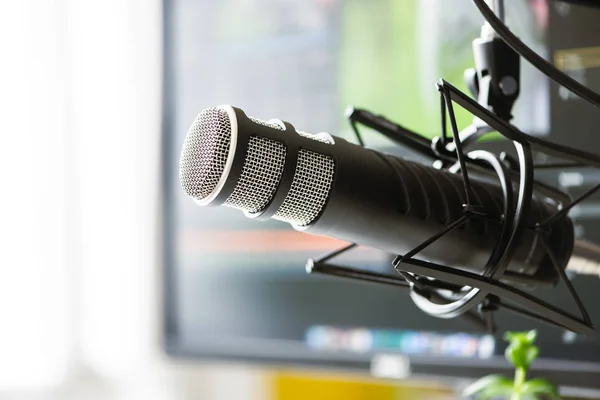 stock image Microphone on the background of the computer monitor.