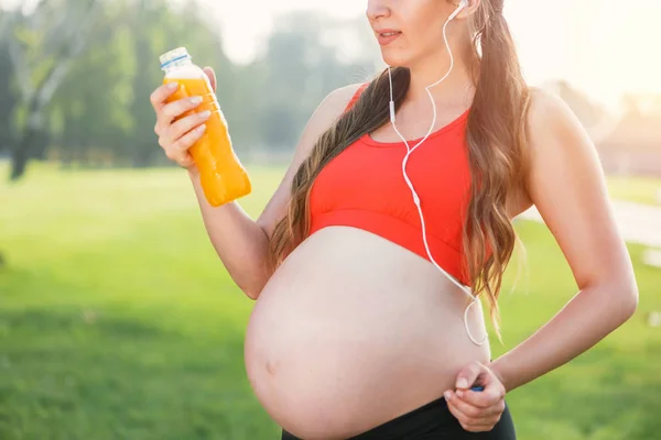 Fitness mulher grávida bebendo água após o treino ao ar livre . — Fotografia de Stock