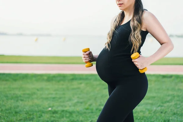 Femme enceinte faisant de l'exercice dans la nature . Image En Vente