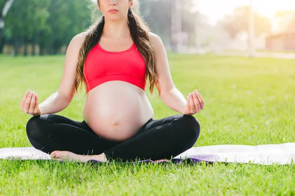 Forme physique enceinte personne souriante tout en pratiquant le yoga à la maison . Photo De Stock