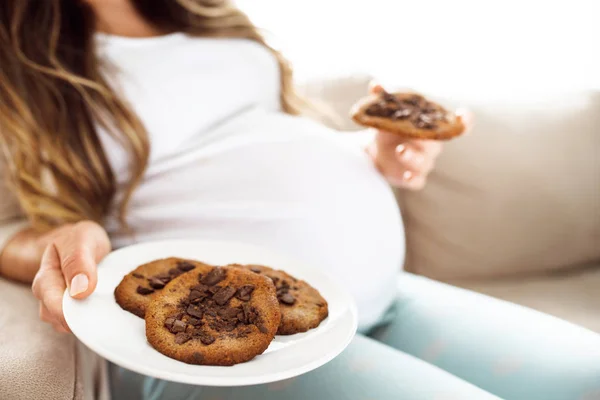 Vue du dessus d'une femme enceinte qui mange des biscuits pour le petit déjeuner . Images De Stock Libres De Droits