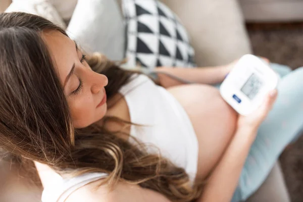 Femme enceinte mesurant la pression artérielle à la maison, bilan de santé de la future maman Images De Stock Libres De Droits