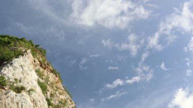 Gündüz vakti kayalık dağların tepeleri. Arka planda mavi gökyüzü ve bulutlarla.