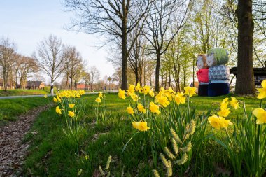 Saman balyalarından insanlar yol kenarında duruyor.