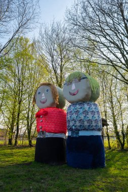 Saman balyalarından insanlar yol kenarında duruyor.