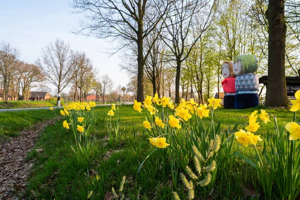 Saman balyalarından insanlar yol kenarında duruyor.