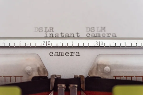 Máquina de escrever com uma folha e as palavras DSLR, DSLM, câmera instantânea — Fotografia de Stock