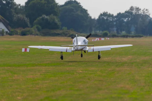 Un avión de aterrizaje en un pequeño aeródromo — Foto de Stock