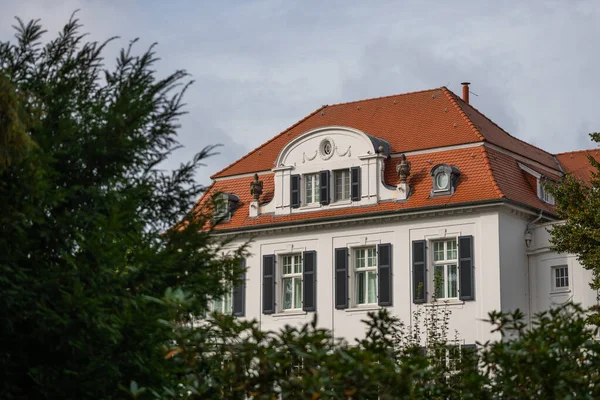 Ein weißes Haus mit roten Dachziegeln und Natur im Vordergrund — Stockfoto