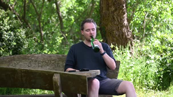 Man Sitter Träbänk Naturen Njuter Sommardagen Och Dricksvatten Från Grön — Stockvideo