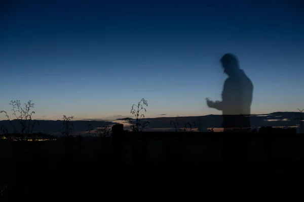 Silhouette  of a person in dark night with bright horizon in the background