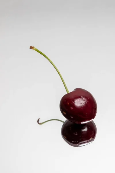 Single Cherry with reflection on a light background