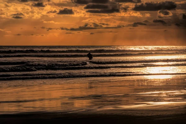 Surfers at sunset on sea with painterly effect