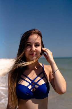 Deniz sahilinde mayo giymiş genç bir kız..