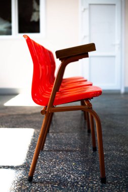 Kırmızı, plastik sandalyeler arka arkaya duruyor. Odada.