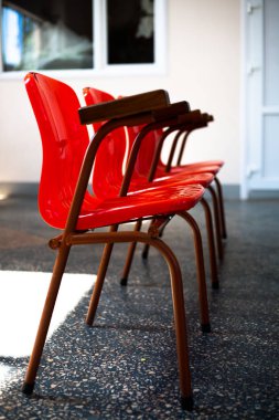 Kırmızı, plastik sandalyeler arka arkaya duruyor. Odada.