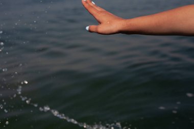 Denizin arka planında kız eli. Denizde tatil.