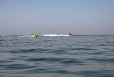 Zıplayan bir tekne tarafından çekilen zıplayan tüpte iki adam.